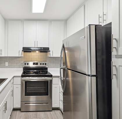 a kitchen with white cabinets and stainless steel appliances